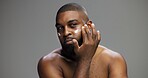 Cosmetics, skincare and cream with black man in studio for salon, grooming and dermatology. Beauty, glow and self care with person and lotion on gray background for hydration, hygiene and shine