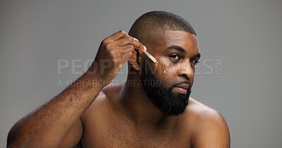 Buy stock photo Beauty, skincare and serum with black man in studio for facial, grooming and dermatology. Cosmetics, glow and self care with person and oil dropper on gray background for hydration, hygiene or shine
