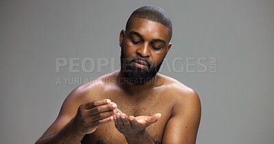 Buy stock photo Facial, skincare and serum with black man in studio for beauty, grooming and dermatology. Cosmetics, glow and self care with person and dropper on gray background for hydration, hygiene and shine