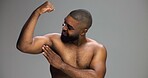 Bicep, body and smile of shirtless black man in studio for fitness, health or strong muscles. Arm, exercise and power with happy African person isolated on gray background for strength or wellness