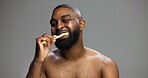 Toothbrush, smile and black man in studio for hygiene, fresh breath and mockup in morning. Portrait, wellness and person brushing teeth for dental care, cleaning or grooming on grey background space
