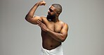 Smile, power and black man flexing arm in studio with health, wellness and confidence in morning grooming. Bathroom space, muscle fitness and biceps of happy person on grey background mockup.