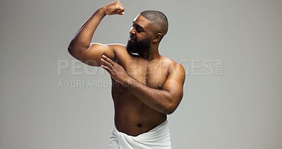 Buy stock photo Smile, power and black man flexing arm in studio with health, wellness and confidence in morning grooming. Bathroom space, muscle fitness and biceps of happy person on grey background mockup.