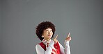 Woman, pointing and information in studio for advertising, announcement or news about us on gray background. Mockup space, presentation or coming soon with hand gesture, sign or direction for launch