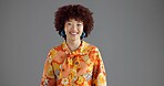 Woman, retro fashion and portrait in studio with smile, confidence and accessories for aesthetic. Creative, designer and vintage style on gray background space with happiness, floral print and afro
