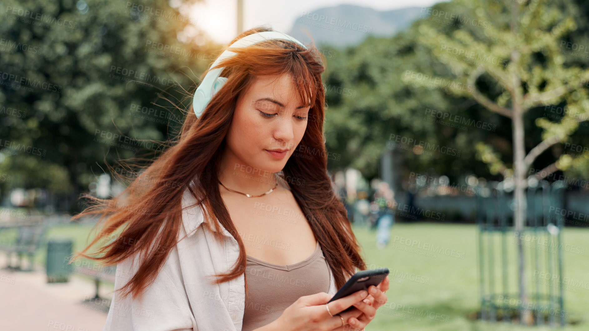 Buy stock photo Park, walking and woman with headphones, smartphone or search online for streaming service on college campus. Outdoor, connection and university student girl with phone, music or podcast subscription