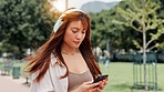 Park, walking and woman with headphones, smartphone or search online for streaming service on college campus. Outdoor, connection and university student girl with phone, music or podcast subscription