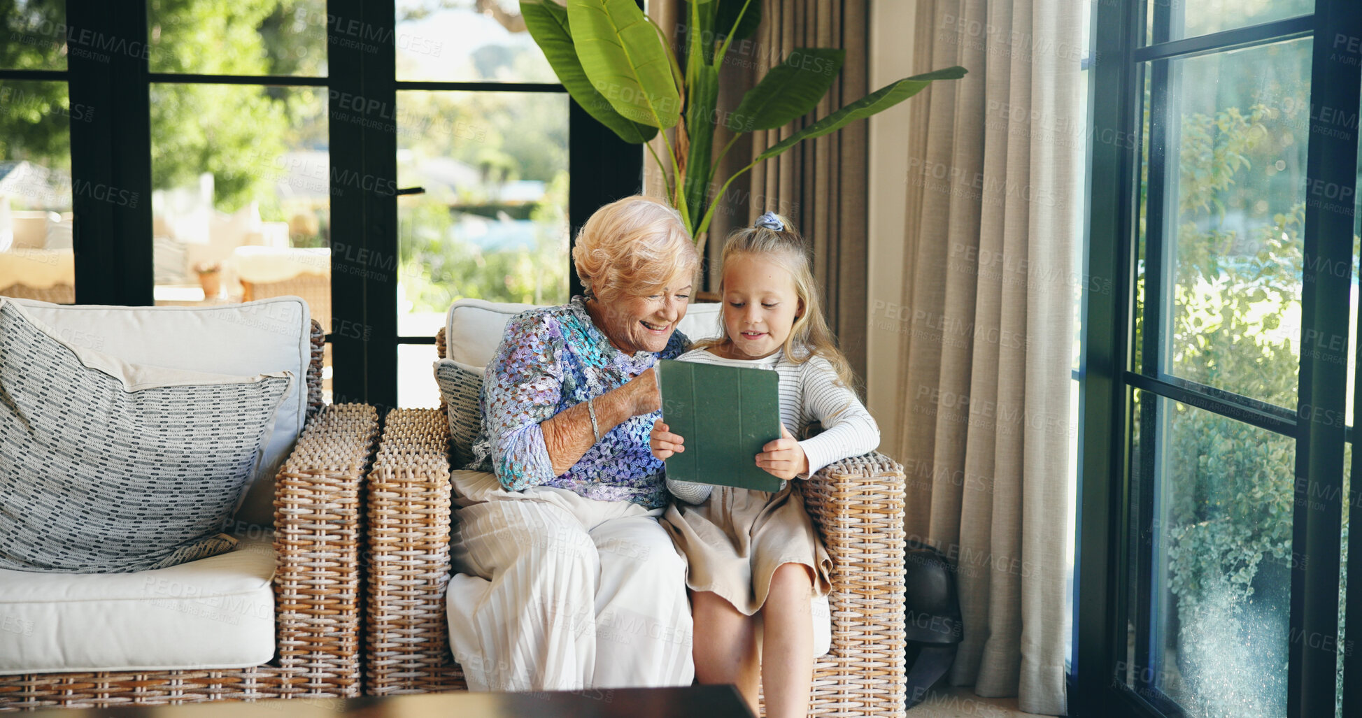 Buy stock photo Relax, grandmother and child with tablet on sofa for playing online game, watching cartoon and weekend visit. Love, old woman and girl with digital app in home for social media and bonding together