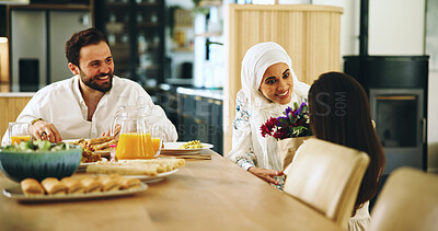 Buy stock photo Muslim, parents and child with flowers at lunch for mothers day surprise, birthday present and support. Happy family, home and woman with bouquet gift at dining table for celebration or special event