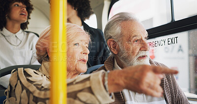 Buy stock photo Old couple, travel and talking on bus ride to destination for public transport, holiday or vacation. People, pointing or elderly tourists by window in city for relationship, retirement or adventure