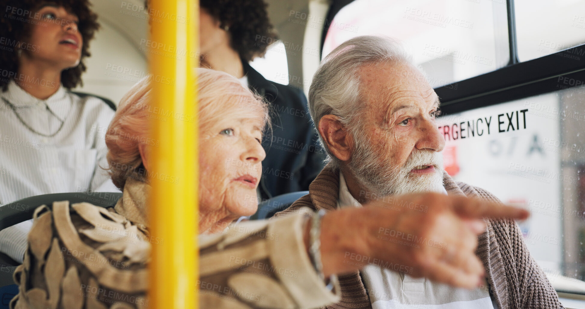 Buy stock photo Old couple, travel and talking on bus ride to destination for public transport, holiday or vacation. People, pointing or elderly tourists by window in city for relationship, retirement or adventure