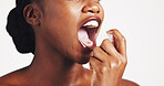 Black woman, oral and mouth spray in studio for hygiene, dental healthcare and mist fragrance. Hand, treatment and female model with product for odor, breathe or plaque problem by white background