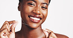 Portrait, black woman and smile with floss in studio for teeth whitening, dental hygiene and oral care. Happy, female person and implant veneers, fresh breathe and clean results on white background