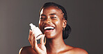 Black woman, skincare and cream in portrait, studio and bottle for dermatology by background. African person, girl and product with lotion for beauty, glow or cosmetics with laughing in Nigeria