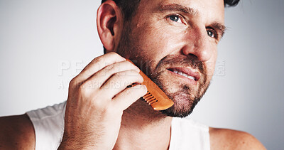 Buy stock photo Thinking, comb and man with beard in studio for wellness, grooming and haircare on white background. Happy, space and person with tools for facial hair styling, growth and shave for morning routine