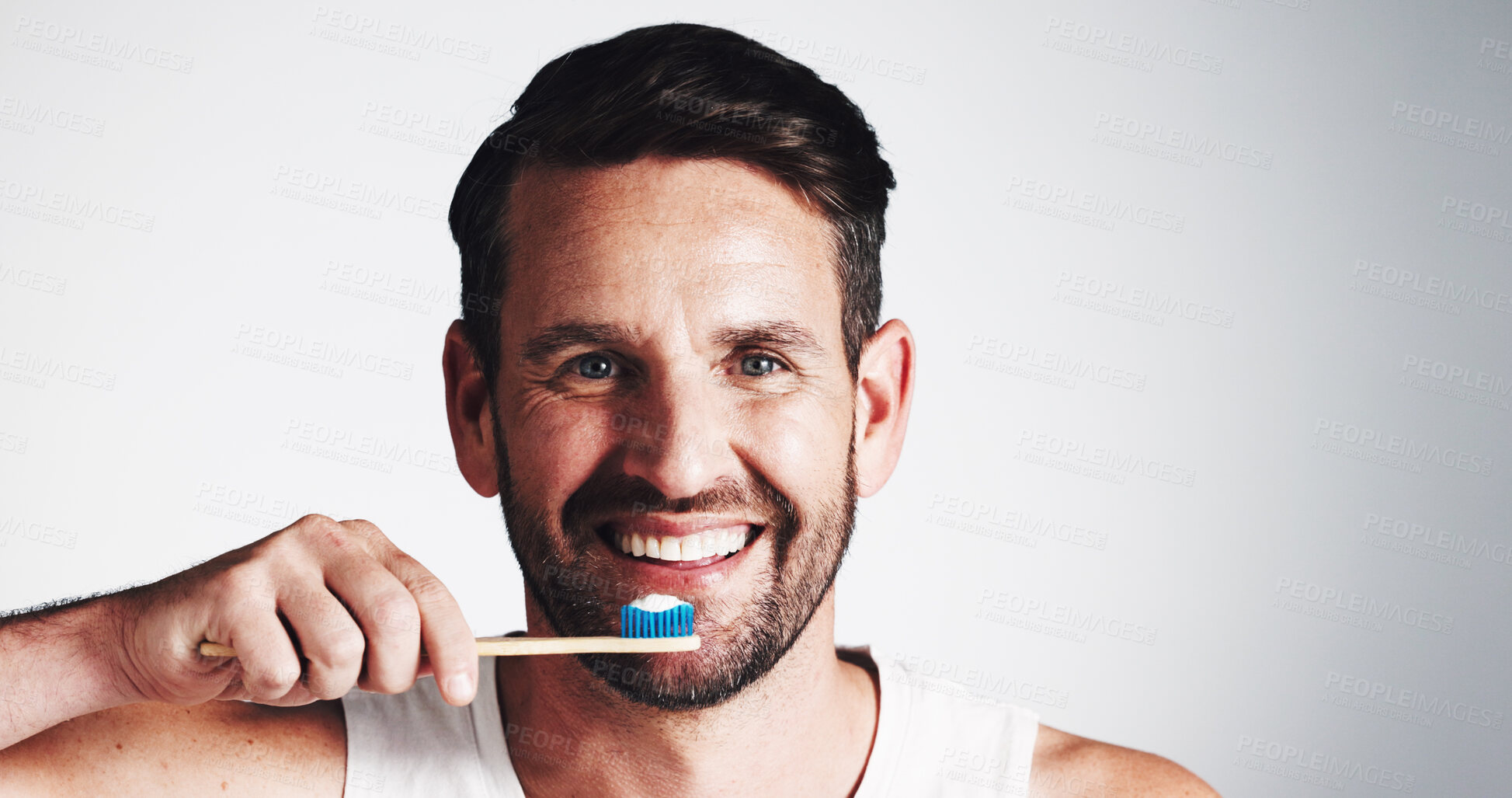 Buy stock photo Portrait, man and smile for brushing teeth in studio for dental hygiene, fresh breath and oral care. Male person, toothbrush and treatment with plaque removal, whitening benefits and white background