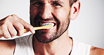 Portrait, man and cleaning teeth in studio for dental hygiene, fresh breath and oral care of wellness. Male person, toothbrush and treatment of plaque removal, whitening benefits and white background