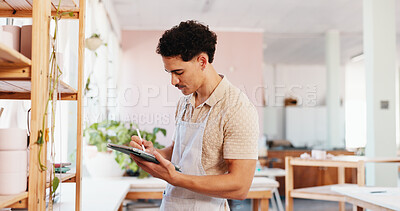 Buy stock photo Ceramic, pottery and man with tablet in studio for inventory management, product inspection and quality control. Startup, potter and digital checklist for stock supply and pricing invoice at shelf