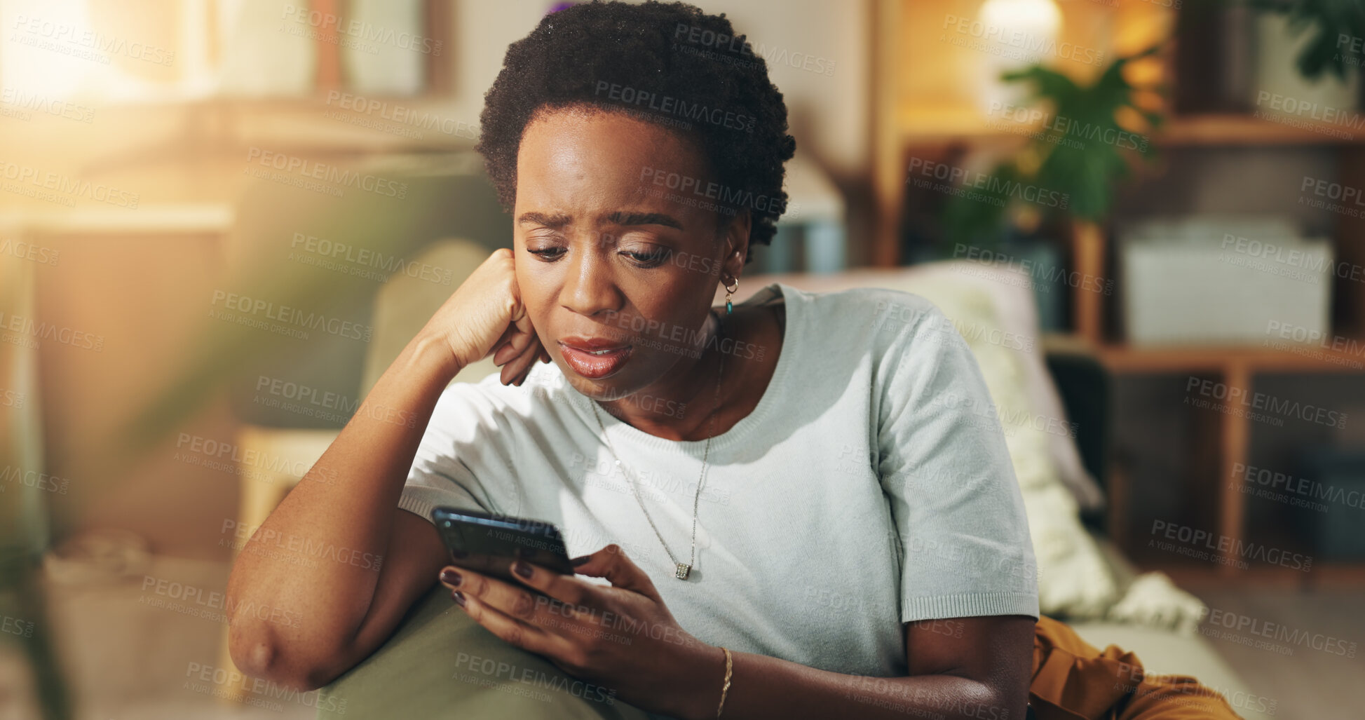 Buy stock photo Black woman, stress and reading with phone on sofa for bad news, article or rumor at home. Female person, user or concern with mobile smartphone for app notification, alert or connection at house