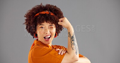 Buy stock photo Portrait, flexing arms and woman with wink, smile and space with confident personality on grey background. Face, happy person or model with gesture, strong or female empowerment with challenge or win