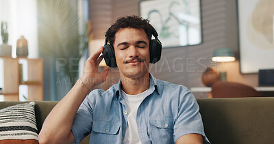 Buy stock photo Relax, music and man with headphones in home for streaming service, hip hop playlist or podcast. Technology, sofa and happy person listening to audiobook, song or audio with sound on weekend to chill
