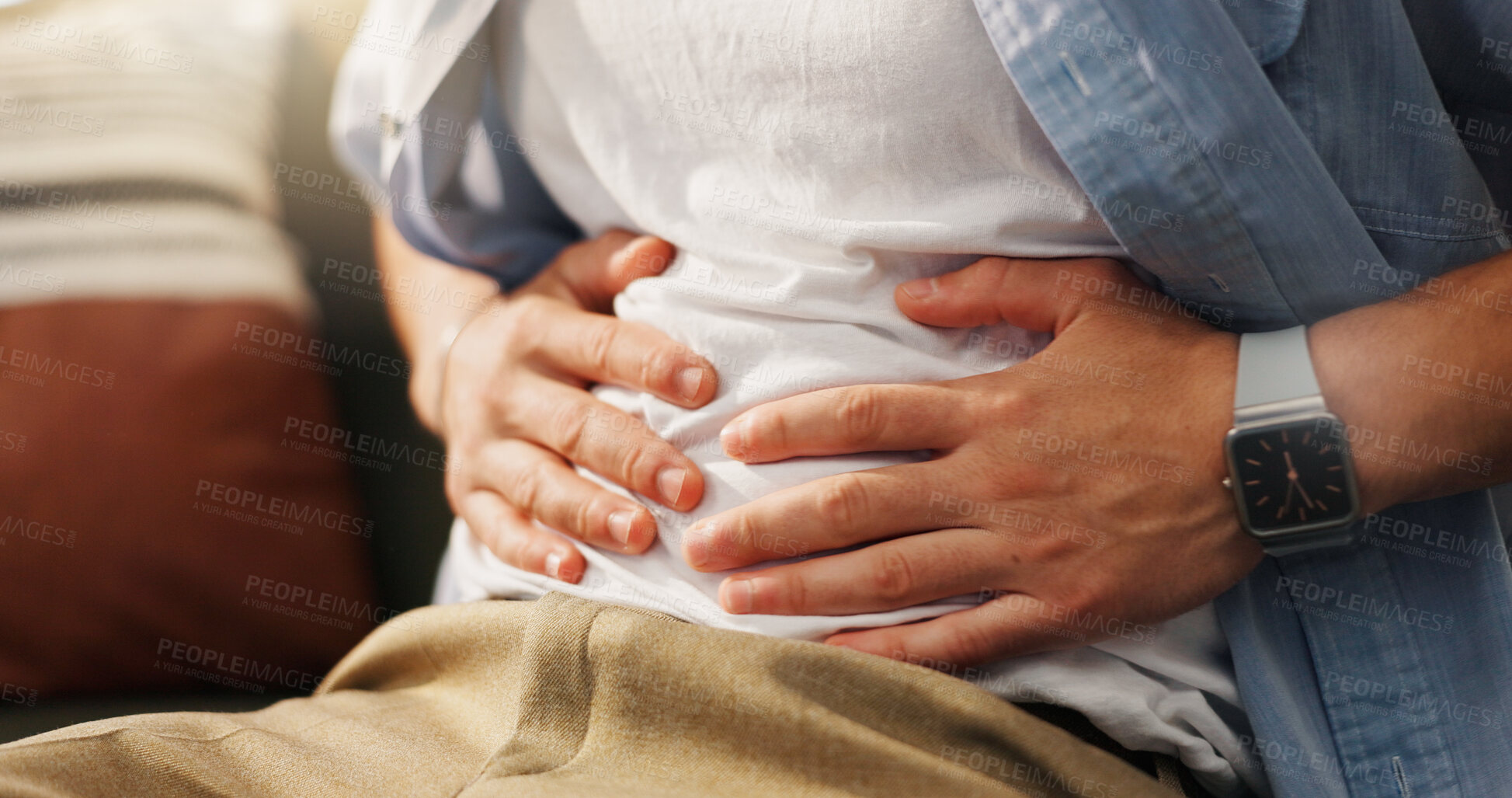 Buy stock photo Stomachache, hands and person in home, pain and man with food poisoning in living room or indigestion. Abdominal, cramps and discomfort on couch, gas and bloating in lounge, diarrhea or constipation