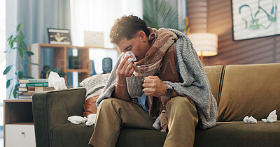 Buy stock photo Man, tissue and blowing nose on sofa in home herbal tea for healing, flu and blanket for recovery. Person, toilet paper and sick with mug for hydration, rest and exhausted on couch at apartment