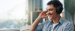 Man, headphones and happy on sofa in home with space, relax and listening to music in living room. Person, smile and audio with streaming, subscription and inspiration on couch at lounge in house