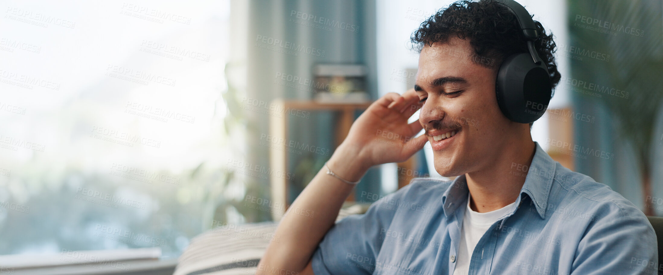 Buy stock photo Man, headphones and happy on sofa in home with space, relax and listening to music in living room. Person, smile and audio with streaming, subscription and inspiration on couch at lounge in house