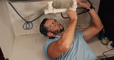Buy stock photo Man, plumber and assessment in kitchen, pipe and sink with search for leak, problem solving and repair in home. Person, handyman and check for water, drain and solution for maintenance at apartment