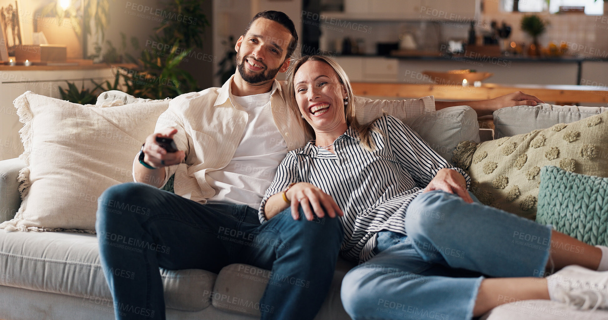 Buy stock photo Couple, relax and watching tv on sofa, laugh and home with funny film, love and bonding in lounge. People, woman and man with remote control on couch for movies, comedy or subscription in living room