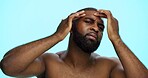 Studio, face check and skincare for man, portrait and acne treatment in morning, serious and dermatology. Blue background, self care and black person with routine for beauty, inspection and worry