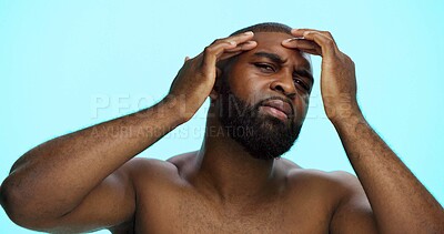 Buy stock photo Studio, face check and skincare for man, portrait and acne treatment in morning, serious and dermatology. Blue background, self care and black person with routine for beauty, inspection and worry