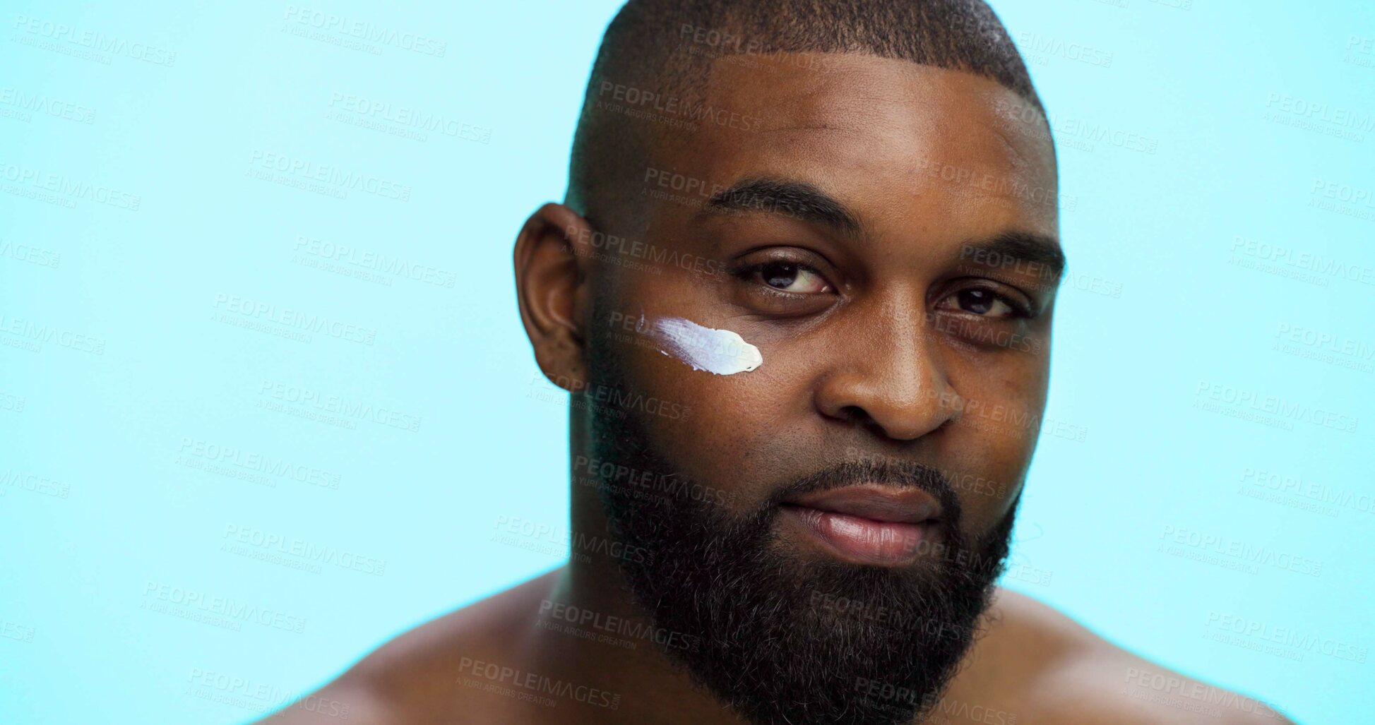Buy stock photo Portrait, cream and black man with cosmetics, skincare and dermatology on blue studio background. African person, space and model with shine, creme and glow with moisturiser, beauty and facial spf