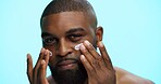 Portrait, cream and black man with skincare, dermatology and facial spf on blue studio background. African person, space and model with shine, creme or lotion with moisturiser, glowing and aesthetic