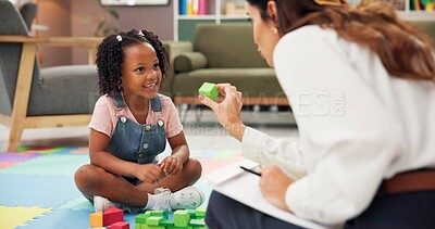 Buy stock photo Child, psychologist or blocks with toys for education or childhood development at therapist office. Female person, kid or elementary student with smile for fun activity, shape or learning difficulty
