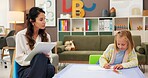Woman, teacher and child in classroom for private tutoring, lesson or assessment at elementary school. Female person, educator or academic therapist monitoring kid or girl for childhood development