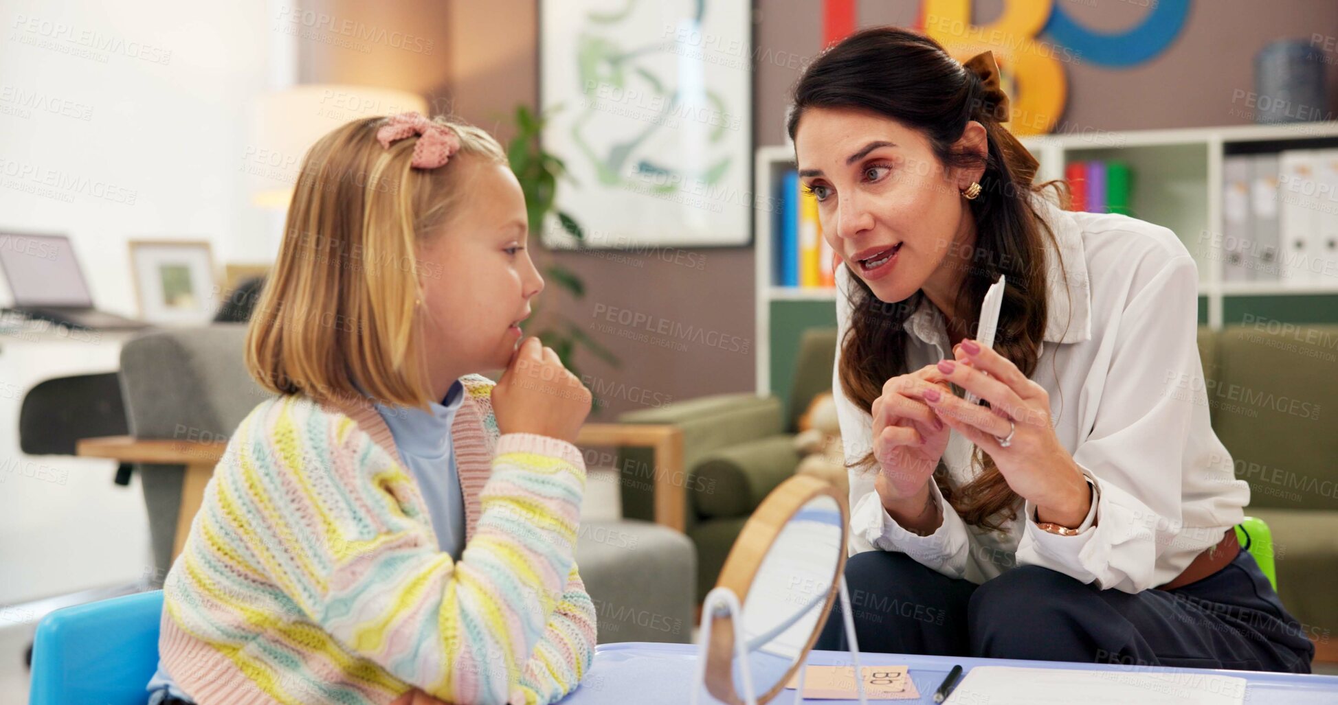 Buy stock photo Mirror, speech therapy and cards with woman and girl for language assessment, sound and teaching. Tongue placement, child development and phonics exam with person and kid for education consulting