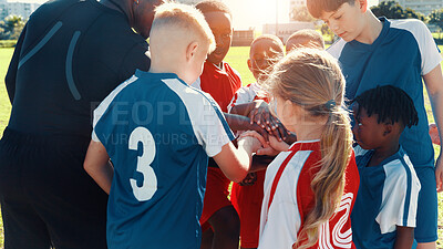 Buy stock photo Hands together, football and coach in huddle with children on field for motivation, game plan and strategy. Competition, training and practice with kids outdoor for sports, soccer player and support