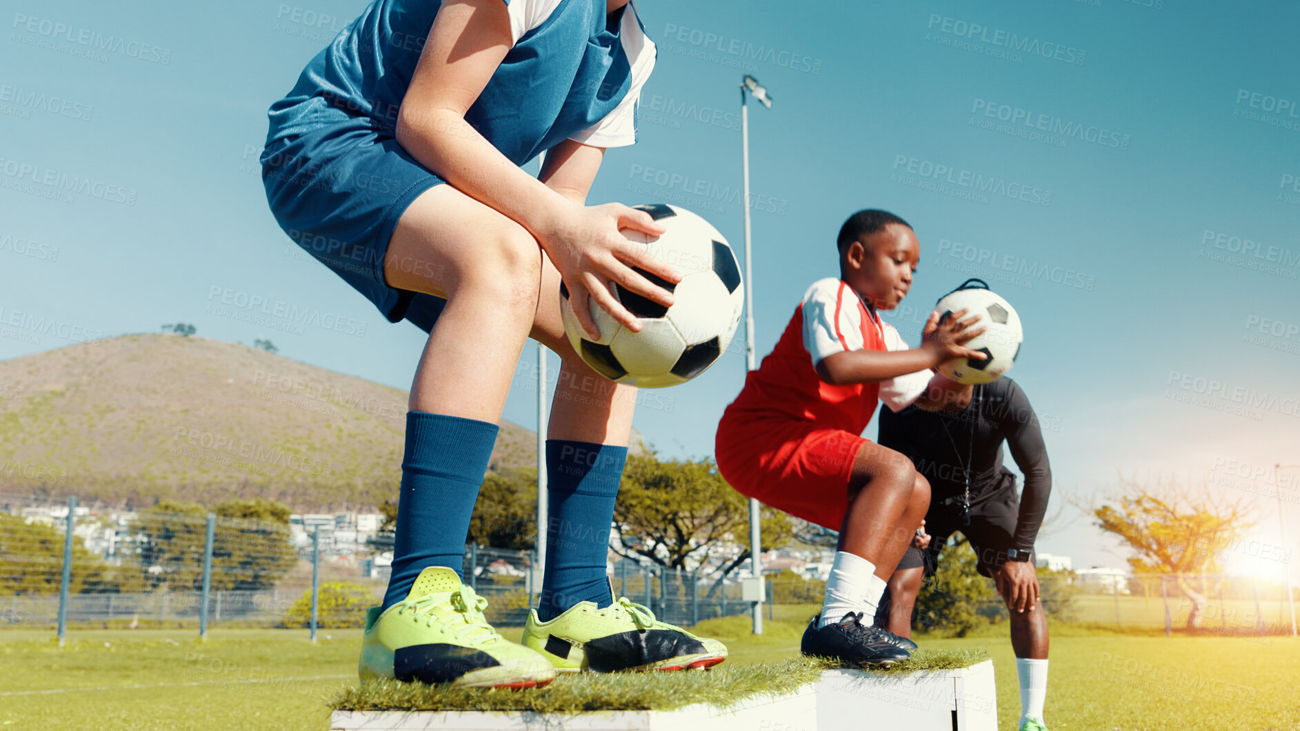Buy stock photo Kids, jumping and ball for soccer practice for fitness training, balance exercise and sports drill. Children, box and equipment for playing game, learning skills and team challenge for match activity