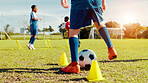 Sports field, legs and children with ball, energy and athlete with coach for practice in morning and cardio. Outdoor, football and kids with sportswear for game, growth and development with fitness