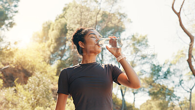 Buy stock photo Woman, drinking water and thirsty in nature for fitness, electrolytes and body detox. Low angle, runner and bottle with H2O for hydration, exercise break and liquid for gut health or digestion aid