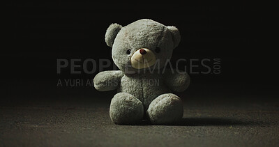 Buy stock photo Night, shadow and teddy bear in studio for loss, isolation and forgotten toy on ground. Dark, floor and stuffed animal on black background for neglect, abandonment and unwanted with lost hope