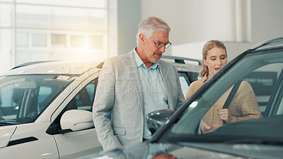 Buy stock photo People, customer and salesman with discussion in car dealership, transport model and rental service. Motor showroom, woman and mature seller with pitch for vehicle features, assistance and talking