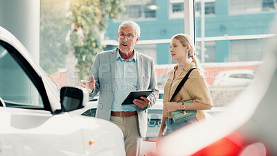 Buy stock photo Tablet, customer and salesman with conversation for car dealership, transport and motor for rental service. Showroom, woman and mature seller with tech for assistance, vehicle features and discussion