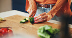 Cooking, woman and hands cut vegetables in kitchen for healthy salad, organic recipe and nutrition. Closeup, person and cucumber ingredients for meal preparation, lunch cuisine and vegan food in home