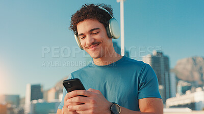 Buy stock photo Happy man, fitness and music with phone in city for workout playlist, songs or tunes. Active, male person or user with smile on mobile smartphone with headphones for audio streaming or app in town