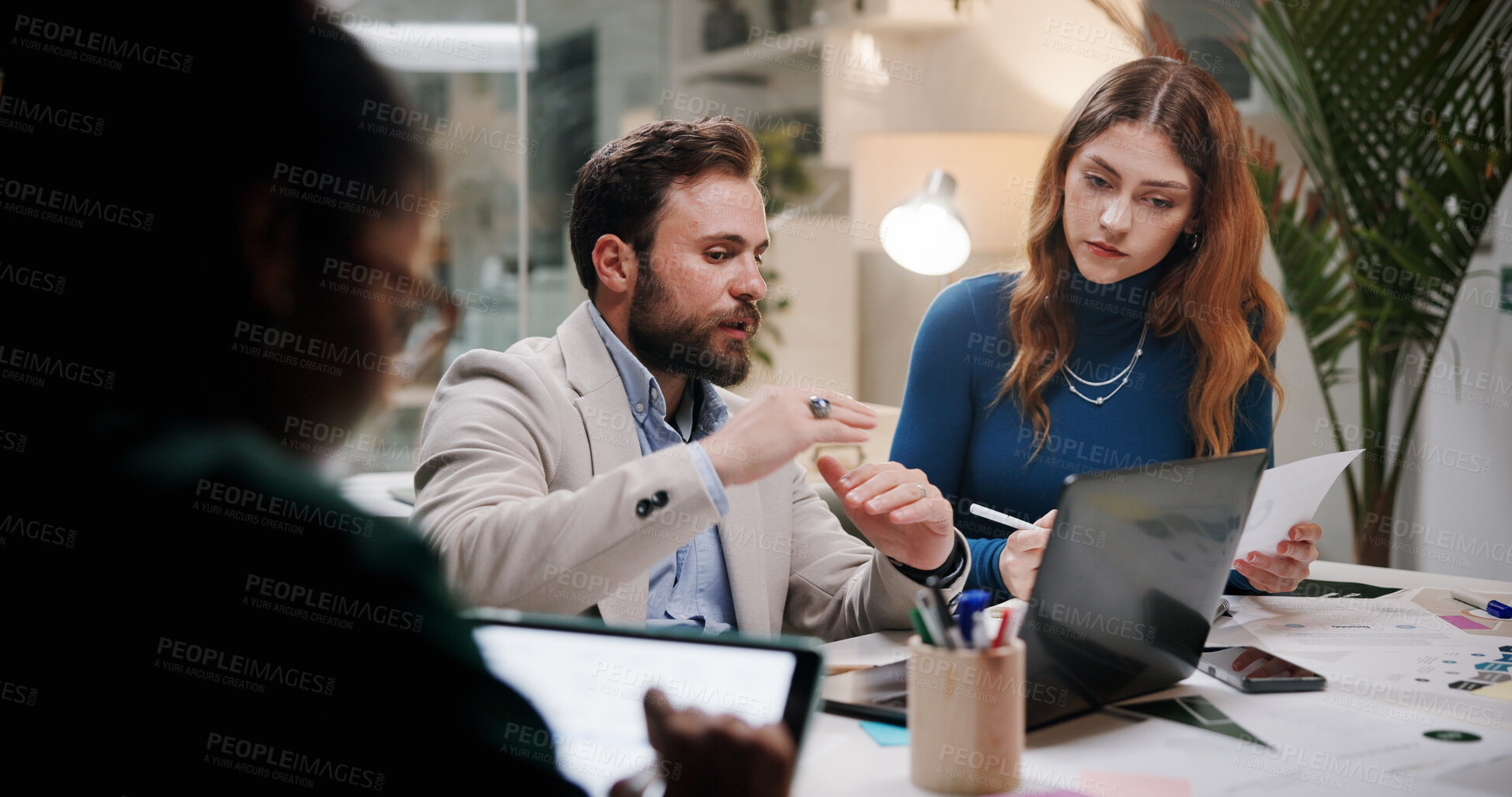 Buy stock photo Business, teamwork or planning with laptop in office at night for marketing campaign, design feedback and strategy. Graphic designer, people and discussion for brand development, ideas and overtime