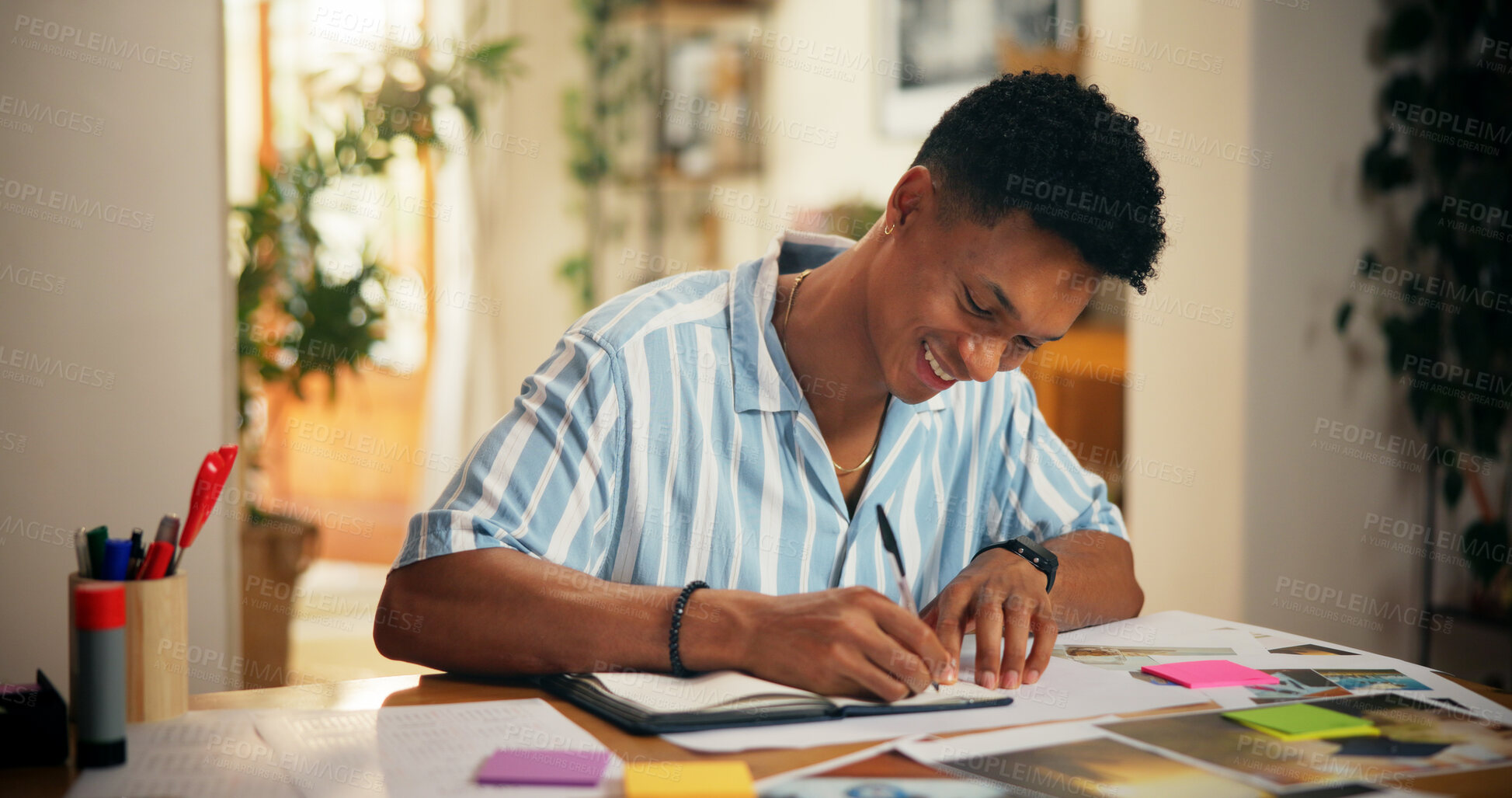 Buy stock photo Man, creative and happy with writing in home for planning vision board, goals timeline and manifestation. Poster, pictures and sticky notes for dream ideas, progress tracking or personal development
