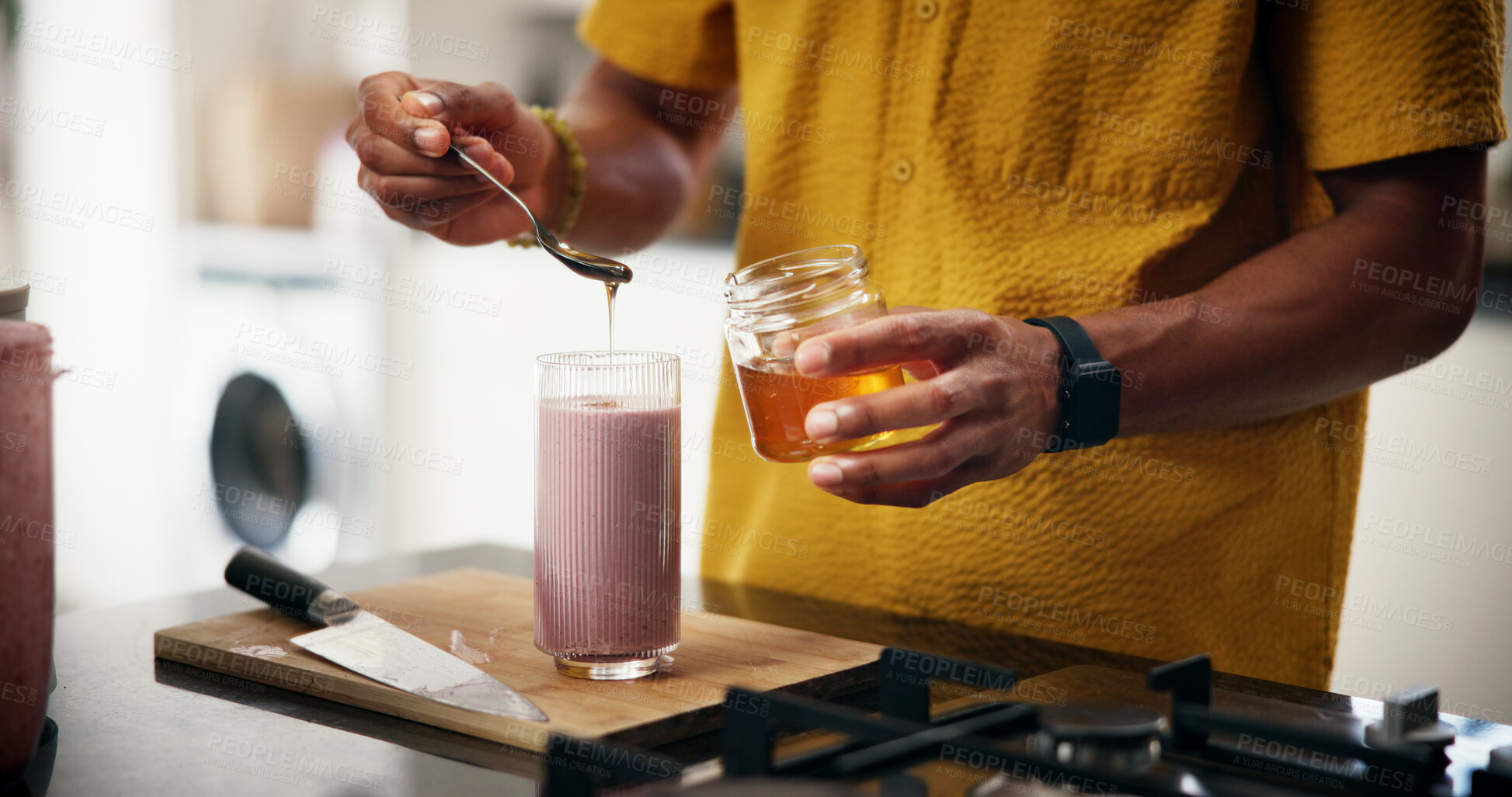 Buy stock photo Honey, wellness and man with smoothie in kitchen in home for liquid diet with breakfast, nutrition or health. Beverage, detox and male person with sweetner for fruit shake for vitamins in apartment.